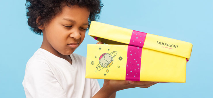 Jongen kijkt in een bedrukte doos - unboxing experience