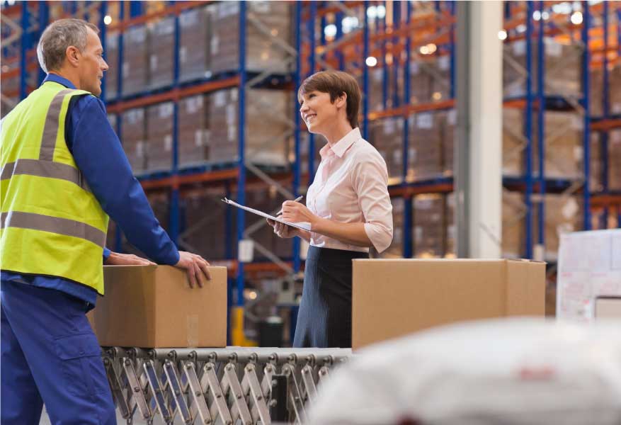 professionnels en conversation dans un entrepôt de marchandises emballées